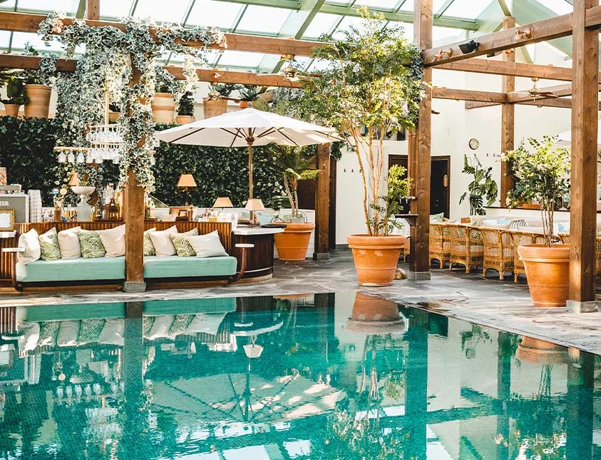 Lyxig poolområde med lounge-sängar och pergola på Falkenberg Strandbad spa och hotell