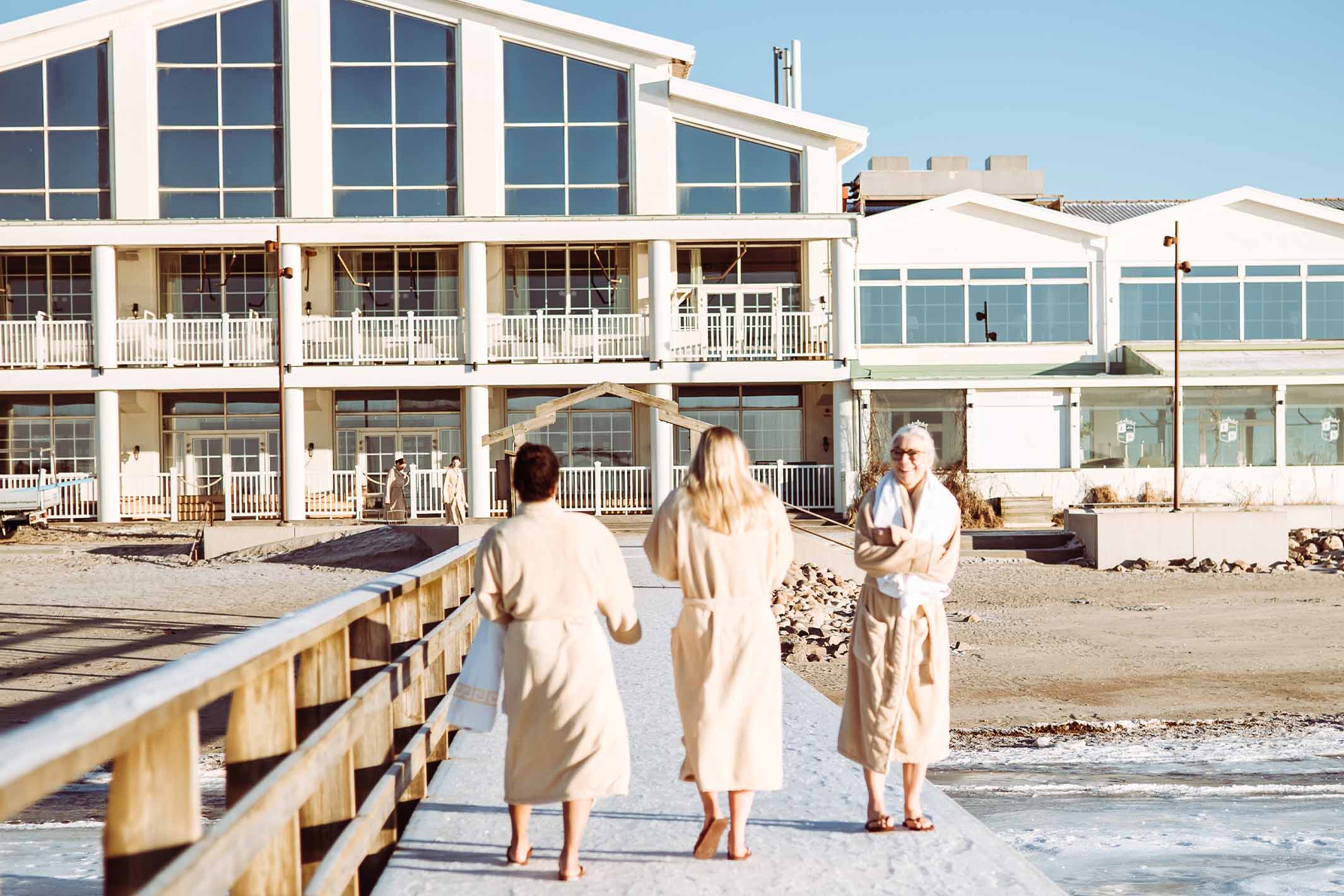 Gäster i badrockar framför hotellfasaden på Falkenberg Strandbad