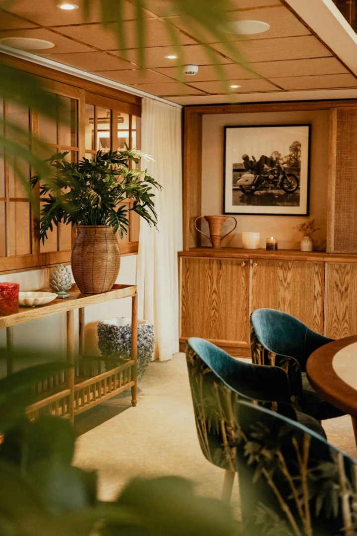 Elegant hotellbar med varma trädetaljer och turkosa sammetsstolar vid Falkenberg Strandbad