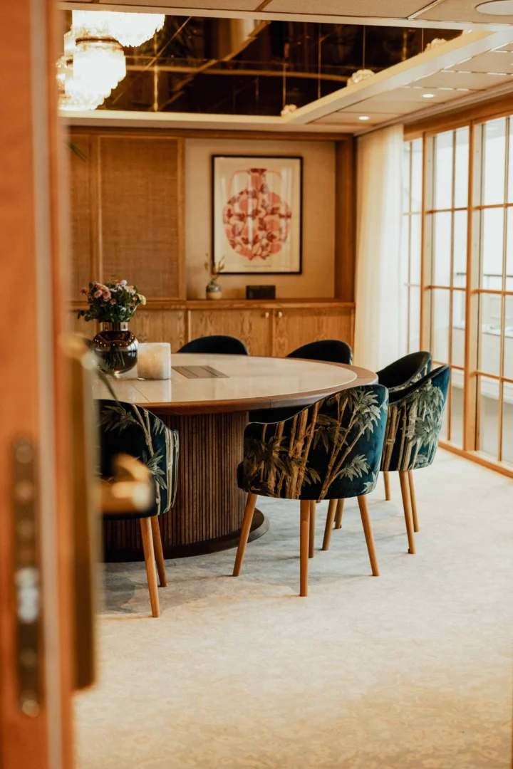Elegant konferensrum med tropiskt mönstrade stolar och havsutsikt genom japanska skjutdörrar på Falkenberg Strandbad