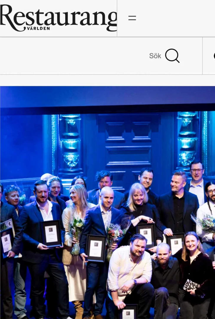 Restaurangteam firar med diplom och blommor vid prisutdelning för Restaurangvärldens utmärkelser