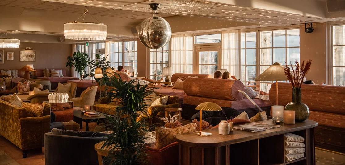 Mysig lounge med havsutsikt där gäster njuter av eftermiddagssolen på Falkenberg Strandbad