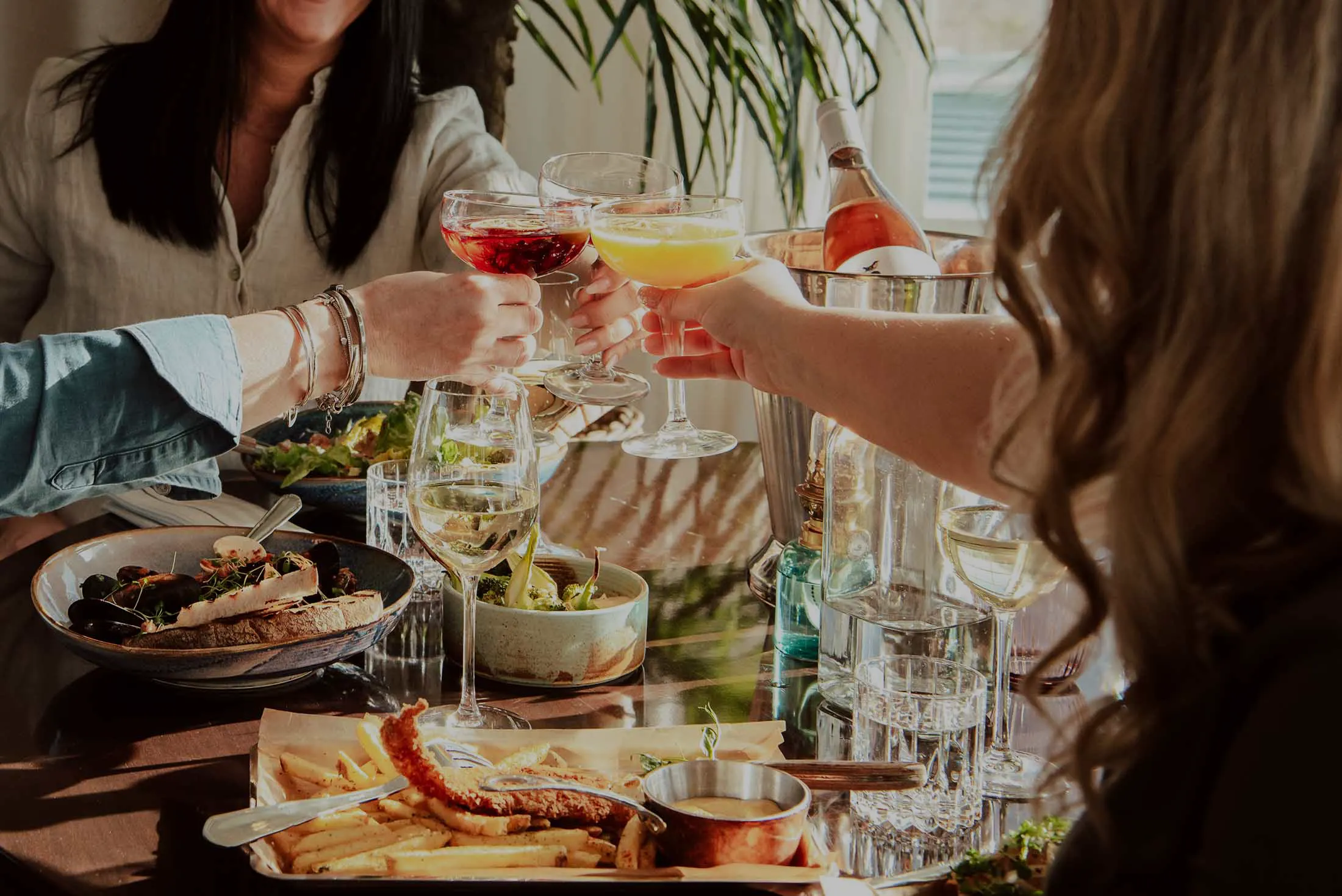 Vänner som skålar med drinkar och äter brunch på Falkenberg Strandbad